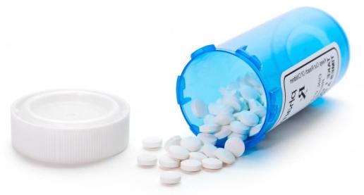 blue-bottle-of-pills-against-white-background